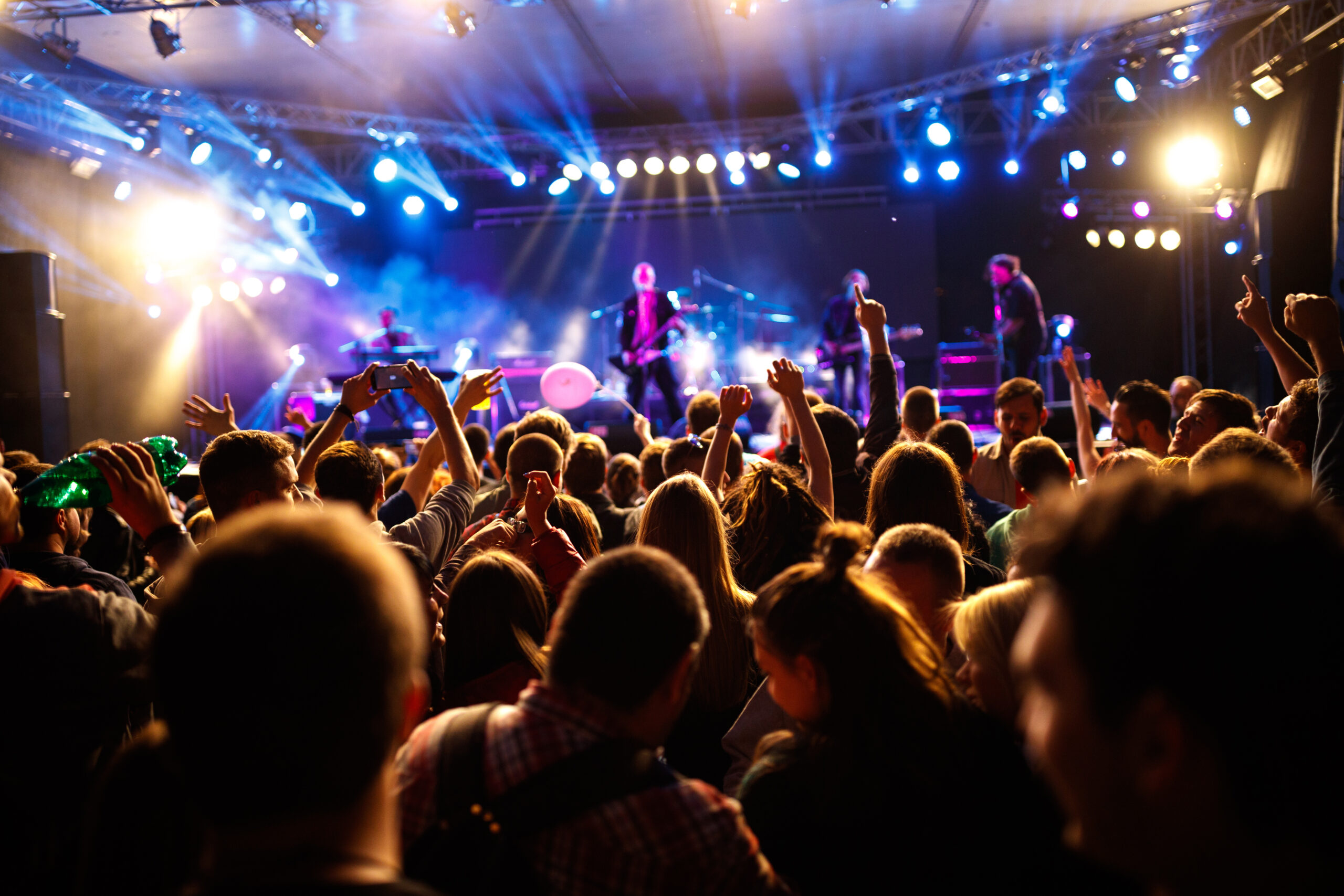 Crowd watching a live band performing on stage at a music event.