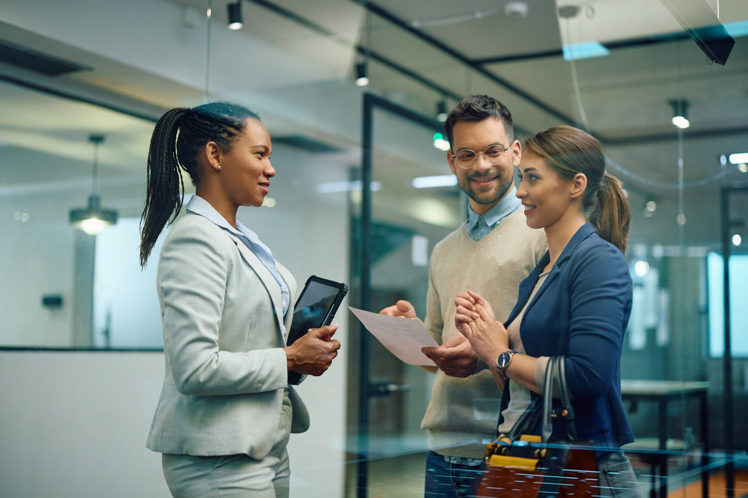 Three colleagues discussing employment matters during a meeting in a modern office.